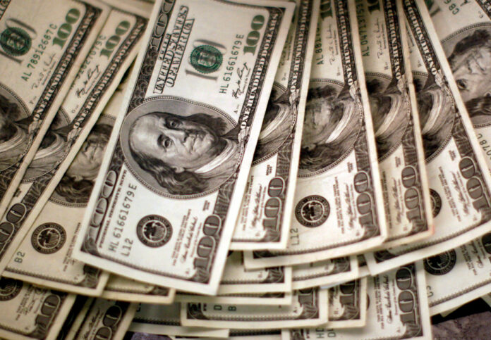 FILE PHOTO: FILE PHOTO: Four thousand U.S. dollars are counted out by a banker at a bank in Westminster